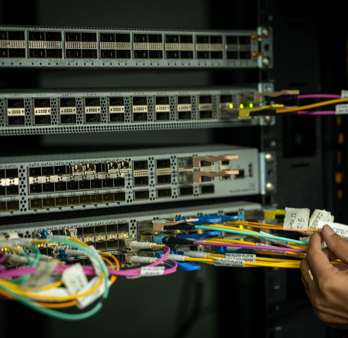A hand patching a switch in a server room