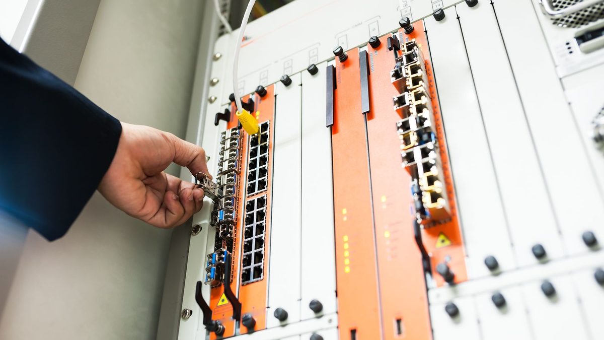 An engineer's hands at a patch panel