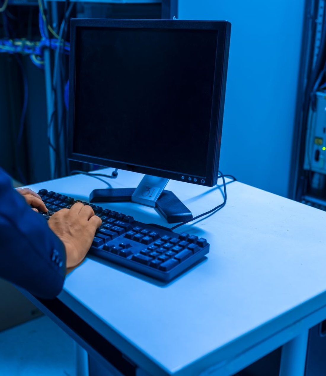 Hands at a console in a network equipment room